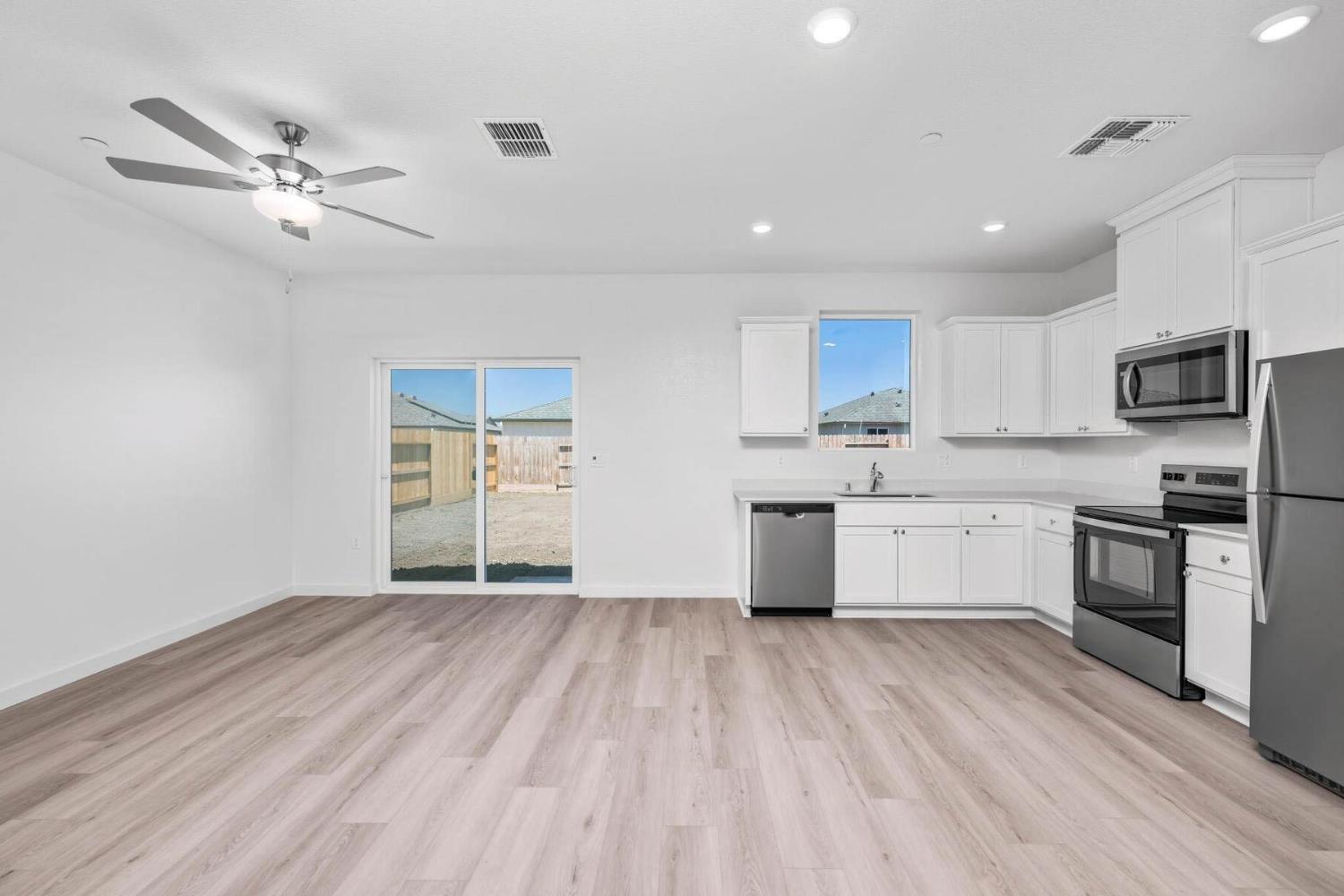 3041 Isley Way Stockton, CA 95212 - Photo 3 of 10 a kitchen with a refrigerator a stove top oven a sink and dishwasher with wooden floor