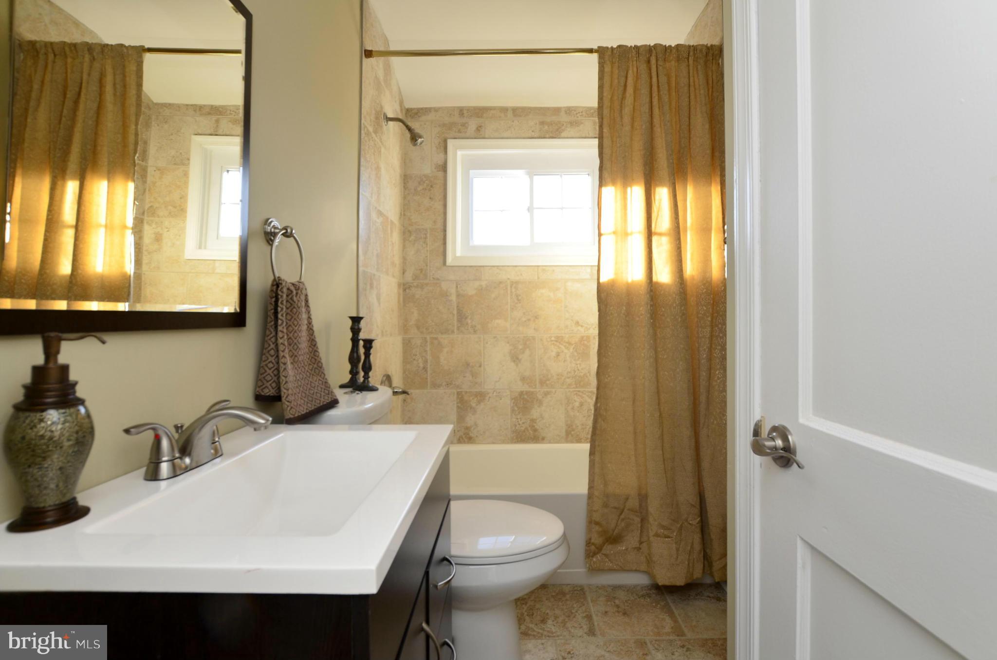8253 Kavanagh Road Baltimore, MD 21222 - Photo 14 of 29 a bathroom with a sink a toilet and shower