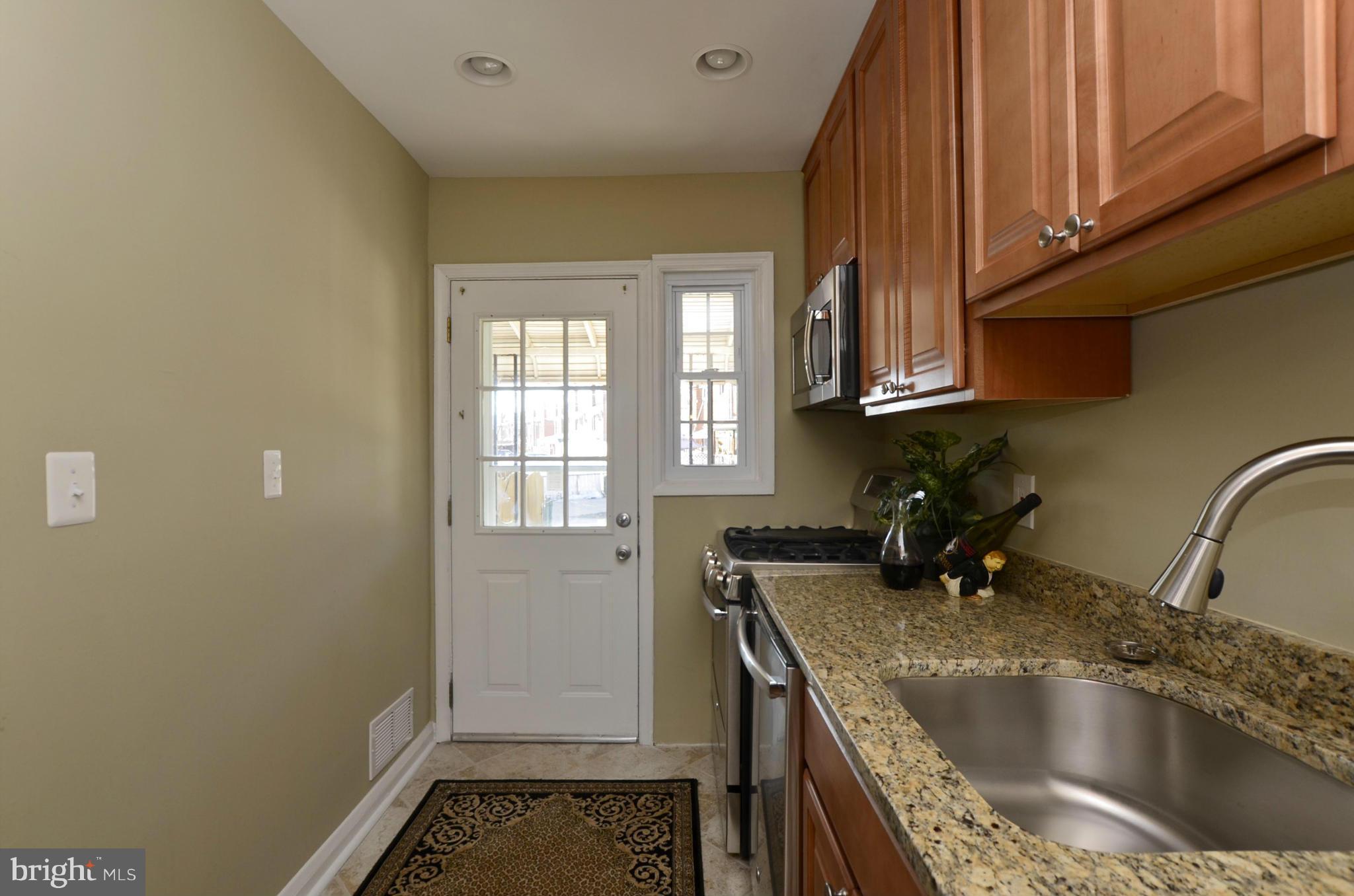8253 Kavanagh Road Baltimore, MD 21222 - Photo 3 of 29 a kitchen with a sink a stove and cabinets
