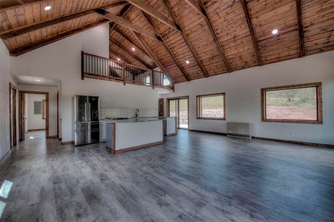 1835 Sheep Ridge Road Fairplay, CO 80440 - Photo 5 of 34 a view of an empty room with wooden floor and a kitchen