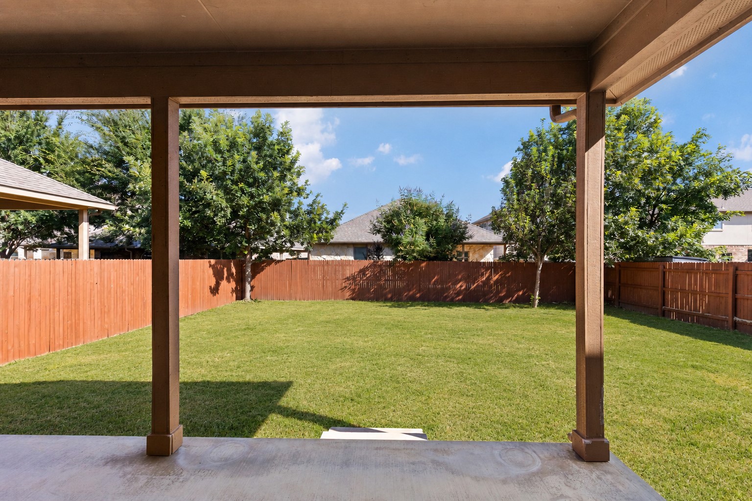 2400 Leonards Pass Leander, TX 78641 - Photo 35 of 40 A spacious backyard with mature trees, fully fenced for privacy and outdoor enjoyment.