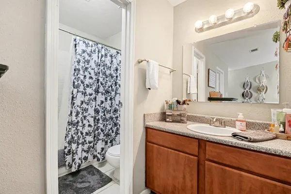 a bathroom with a granite countertop sink a mirror a vanity and a shower