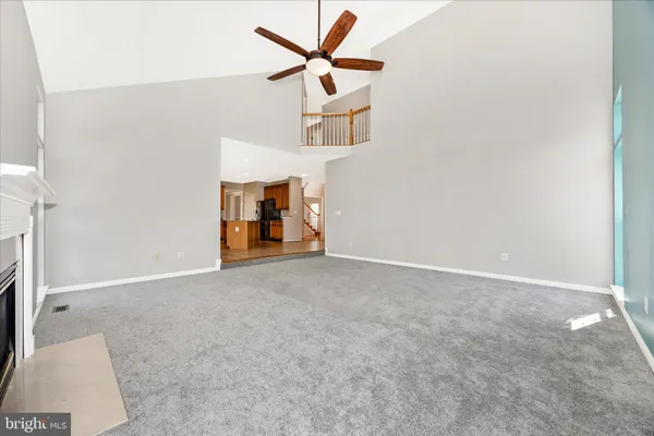 a view of an empty room with stairs and a window