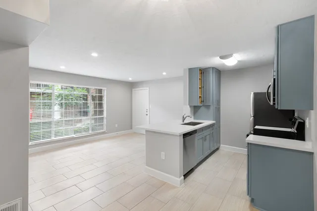 a large kitchen with stainless steel appliances granite countertop a large counter top a stove and a refrigerator