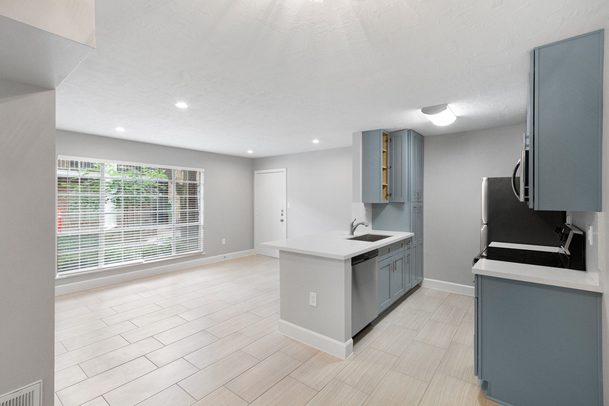 a large kitchen with stainless steel appliances granite countertop a large counter top a stove and a refrigerator