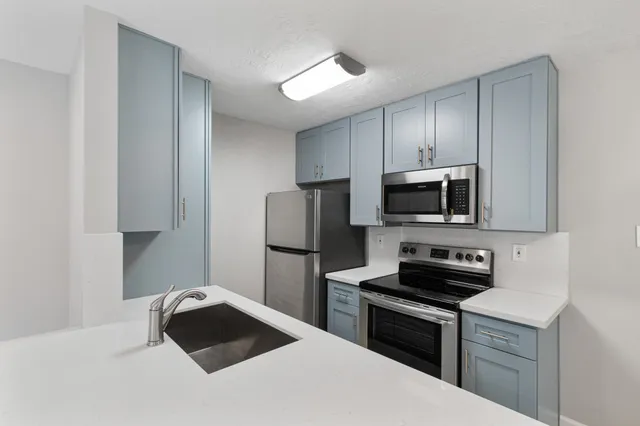 a kitchen with stainless steel appliances a stove microwave and refrigerator