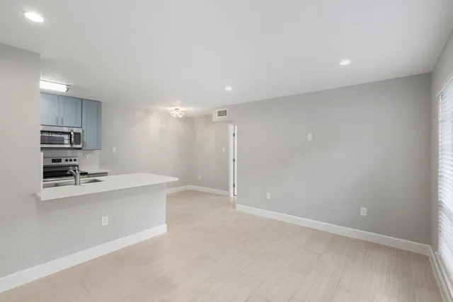 a large kitchen with a sink stainless steel appliances and cabinets