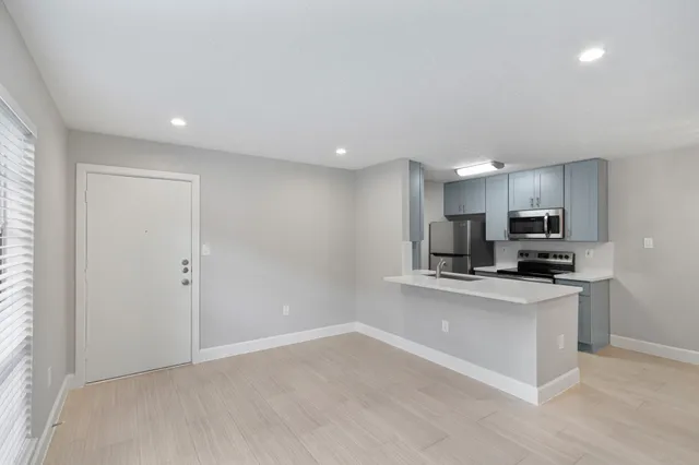 a kitchen with stainless steel appliances a sink and a refrigerator