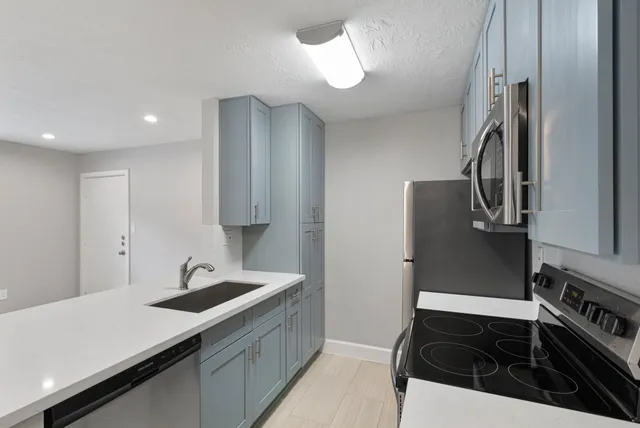 a kitchen with granite countertop a stove and a microwave