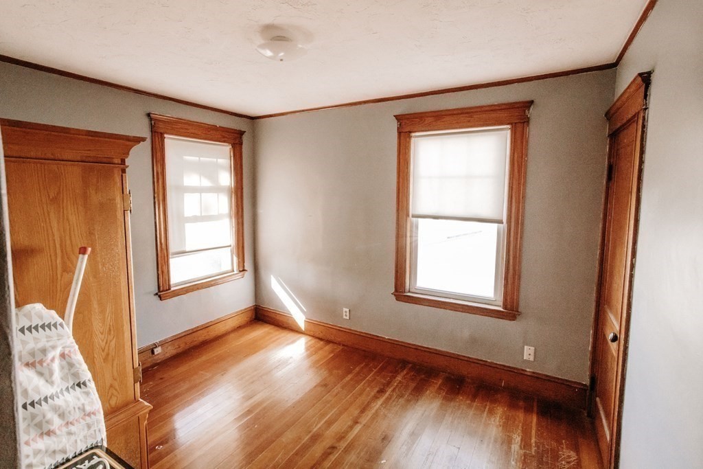 147 Train Street Boston, MA 02122 - Photo 14 of 27 an empty room with wooden floor and windows