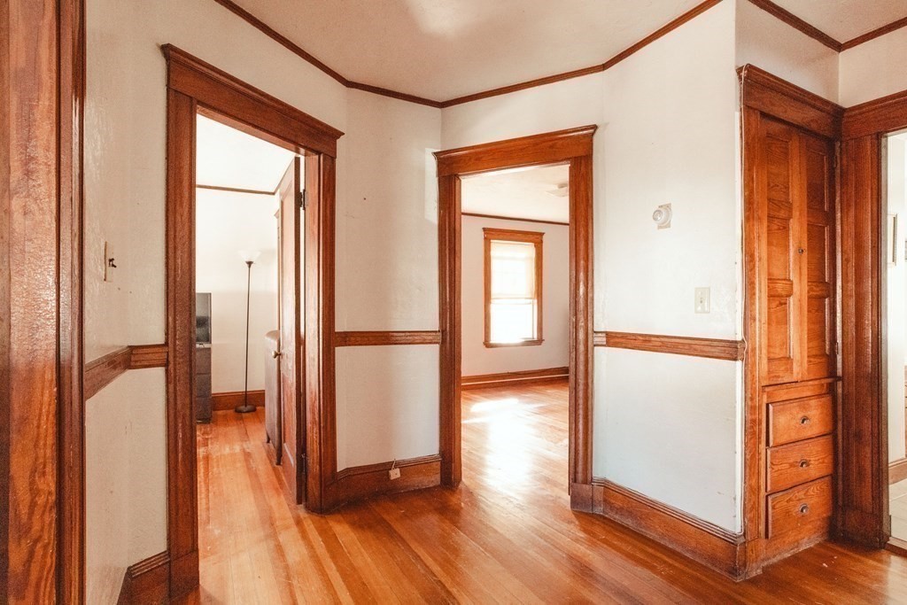 147 Train Street Boston, MA 02122 - Photo 18 of 27 an empty room with wooden floor and a kitchen