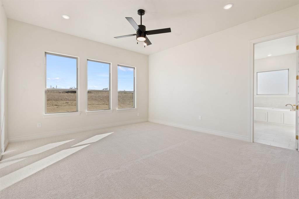 412 Collum View Azle, TX 76020 - Photo 11 of 29 an empty room with a ceiling fan and windows