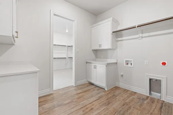 a view of empty room with wooden floor and cabinet
