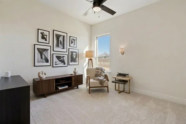 an empty room with a ceiling fan and carpet
