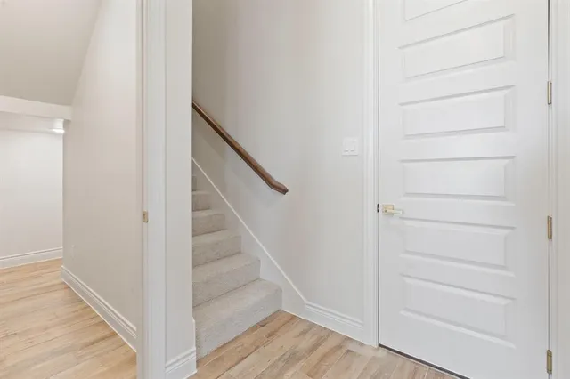 a view of a hallway with wooden floor and entryway