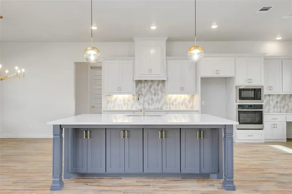 a kitchen with kitchen island granite countertop wooden cabinets and refrigerator