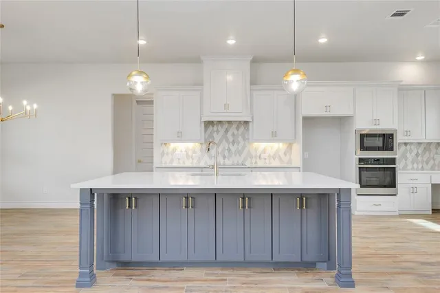a kitchen with kitchen island granite countertop wooden cabinets and refrigerator