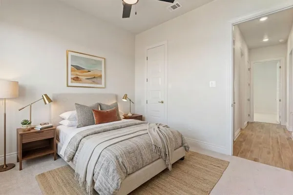 a view of an empty room with a fireplace and a ceiling fan