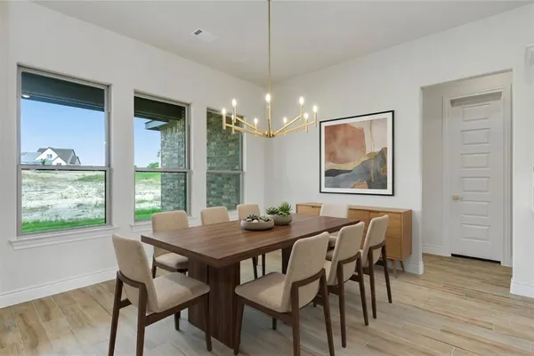 a dining room with furniture a chandelier and wooden floor