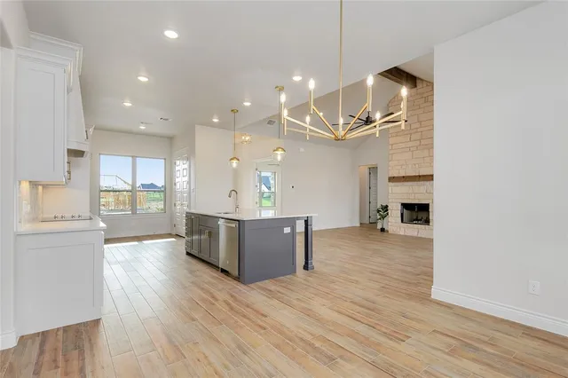a large kitchen with a wooden floor and stainless steel appliances