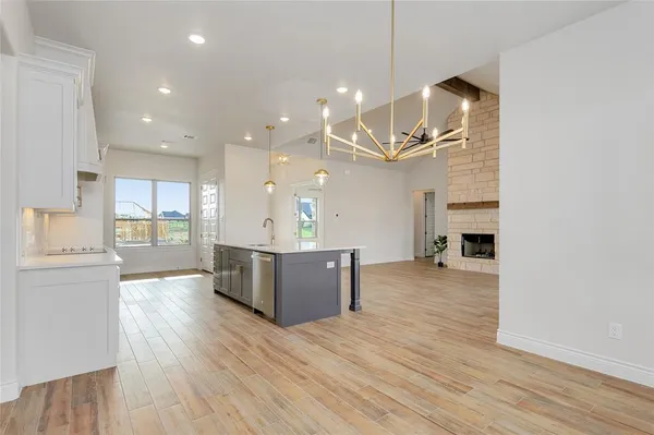 a large kitchen with a wooden floor and stainless steel appliances
