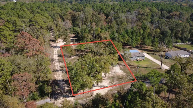 an aerial view of residential house with outdoor space and trees all around