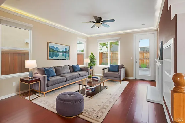 a living room with furniture a large window and a wooden floor