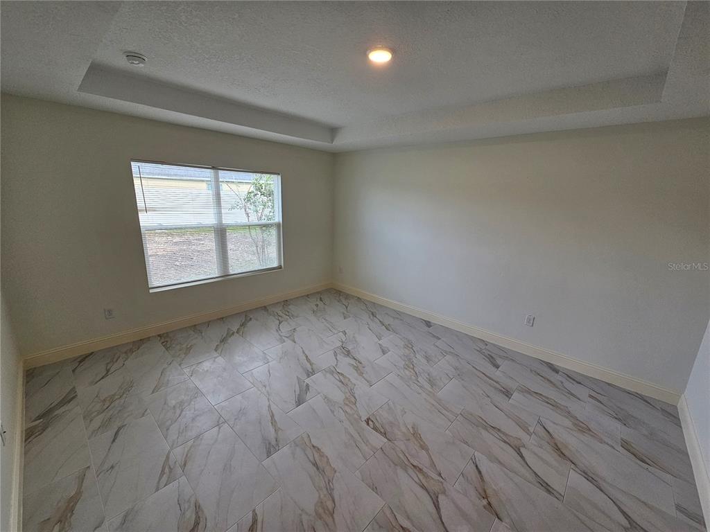 1640 Strathmore Circle Mount Dora, FL 32757 - Photo 11 of 18 an empty room with wooden floor and windows