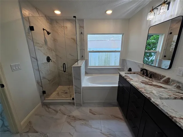 a bathroom with a tub sink and mirror