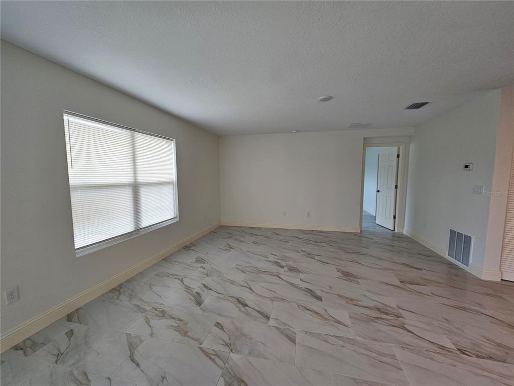 1640 Strathmore Circle Mount Dora, FL 32757 - Photo 5 of 18 an empty room with wooden floor and windows
