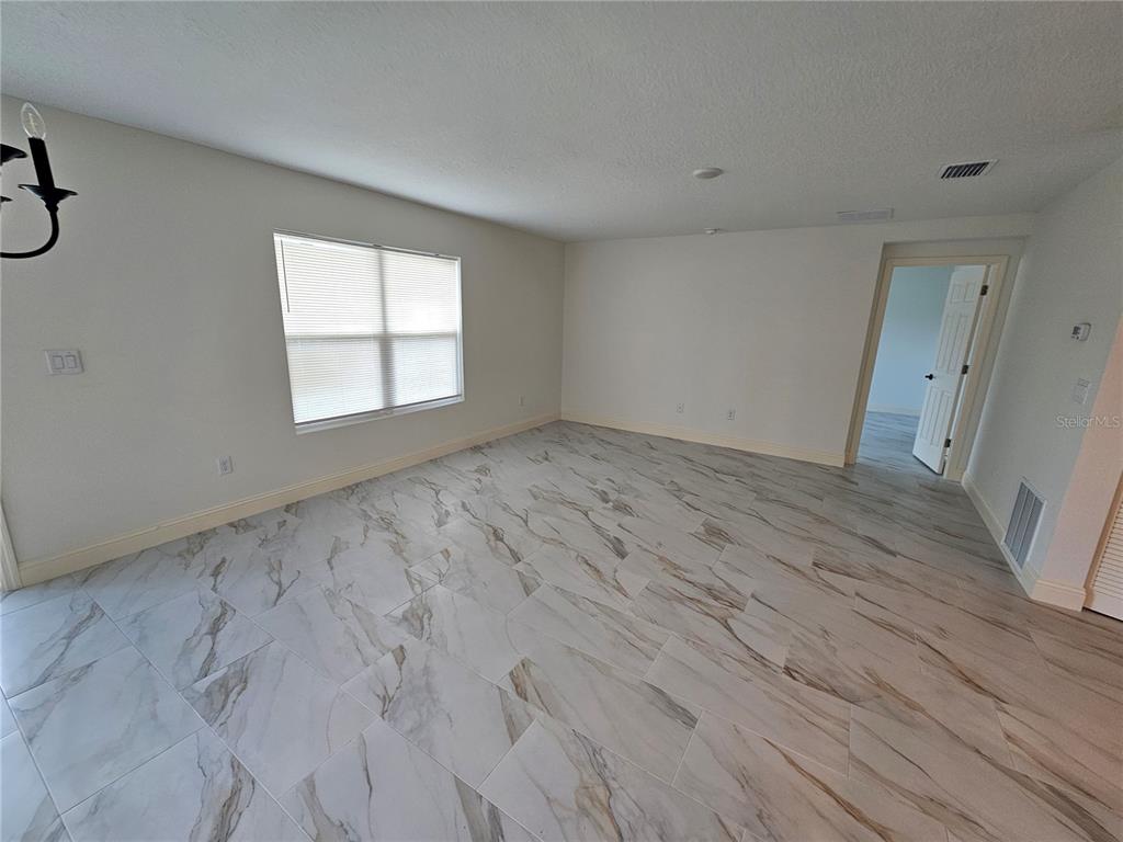 1640 Strathmore Circle Mount Dora, FL 32757 - Photo 6 of 18 an empty room with wooden floor and windows