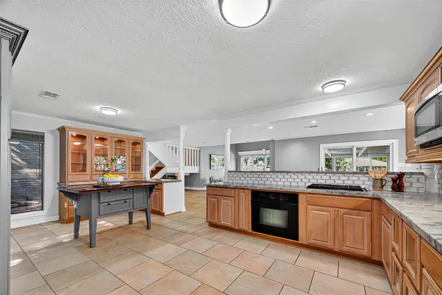 a kitchen with granite countertop a sink and a stove