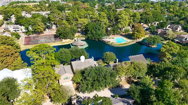 an aerial view of a house with a yard and lake view