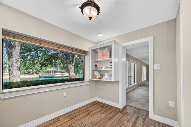 a view of a livingroom with wooden floor and a large window