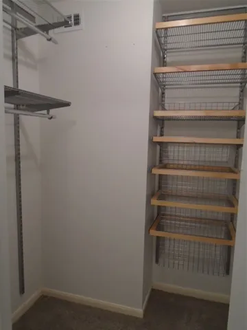 a view of walk in closet with empty racks