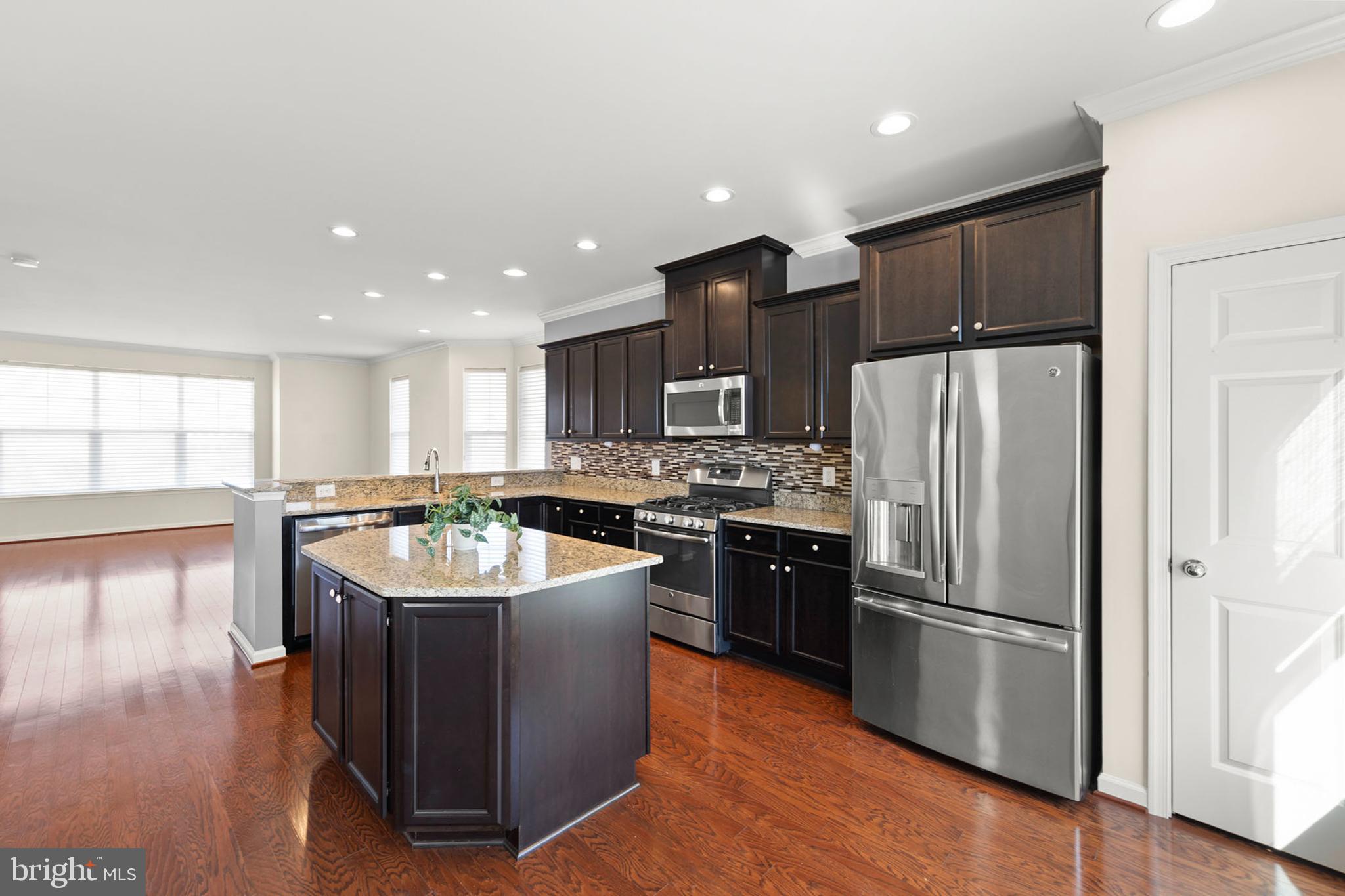 210 Flyfoot Drive Stephenson, VA 22656 - Photo 17 of 38 a kitchen with stainless steel appliances granite countertop a refrigerator a sink dishwasher a oven with white cabinets and wooden floor