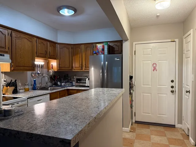 a kitchen with stainless steel appliances granite countertop a refrigerator a sink and a stove