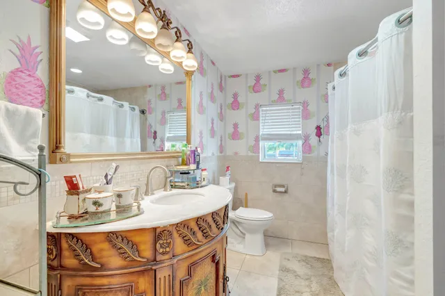 a bedroom with two beds and a large mirror next to a window