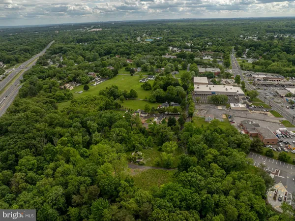 an aerial view of residential houses with outdoor space and trees