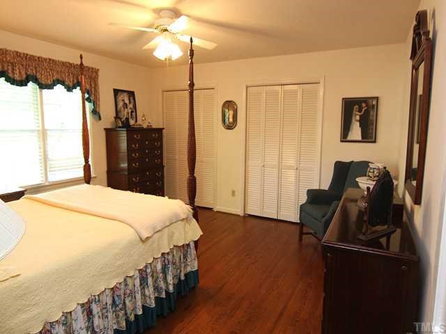 1109 Hunting Ridge Road Raleigh, NC 27615 - Photo 9 of 12 a bedroom with a bed and a chandelier