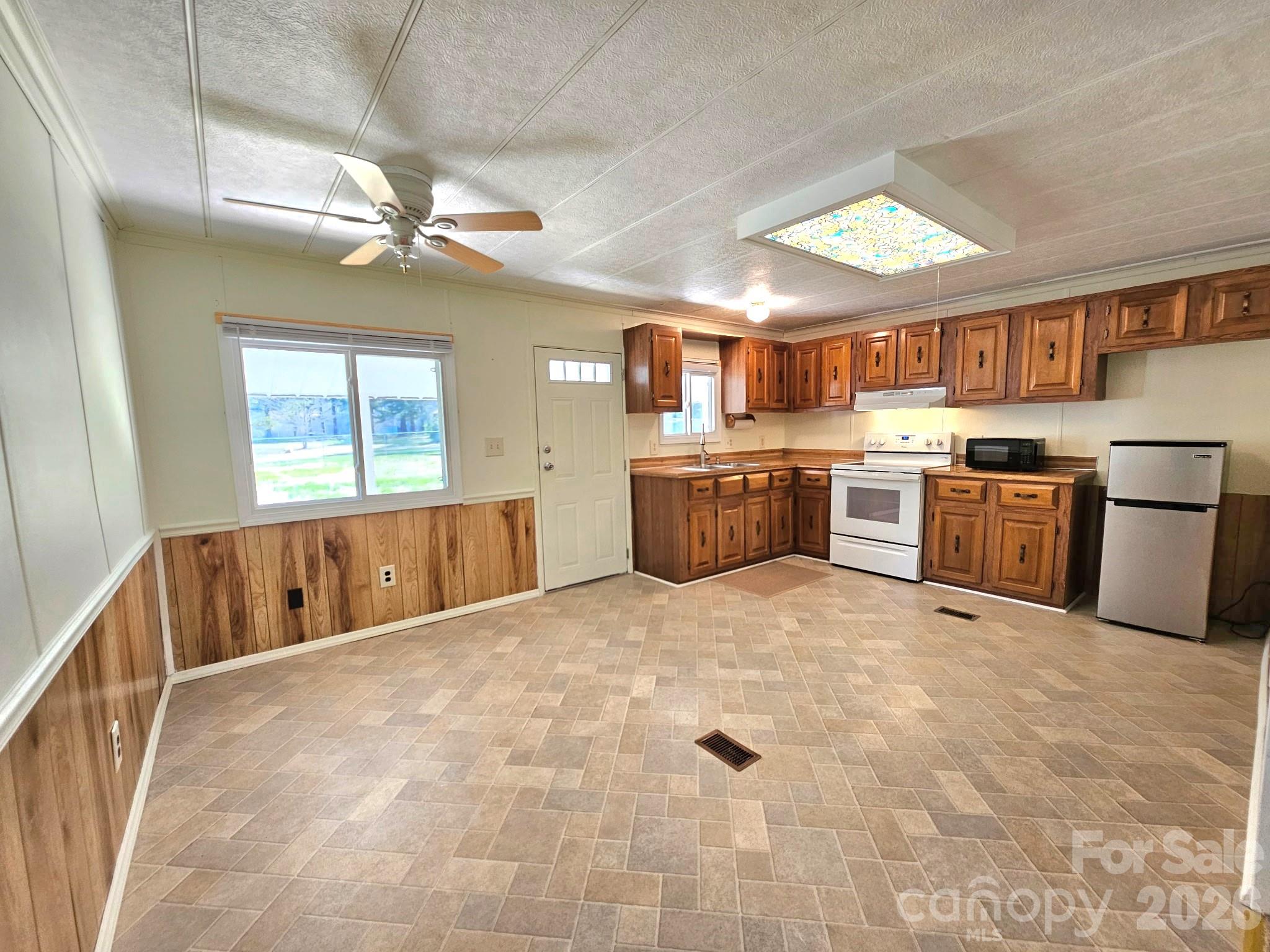 44716 Gold Branch Road Richfield, NC 28137 - Photo 12 of 47 a large white kitchen with a stove top oven a sink dishwasher a dining table and chairs with wooden floor
