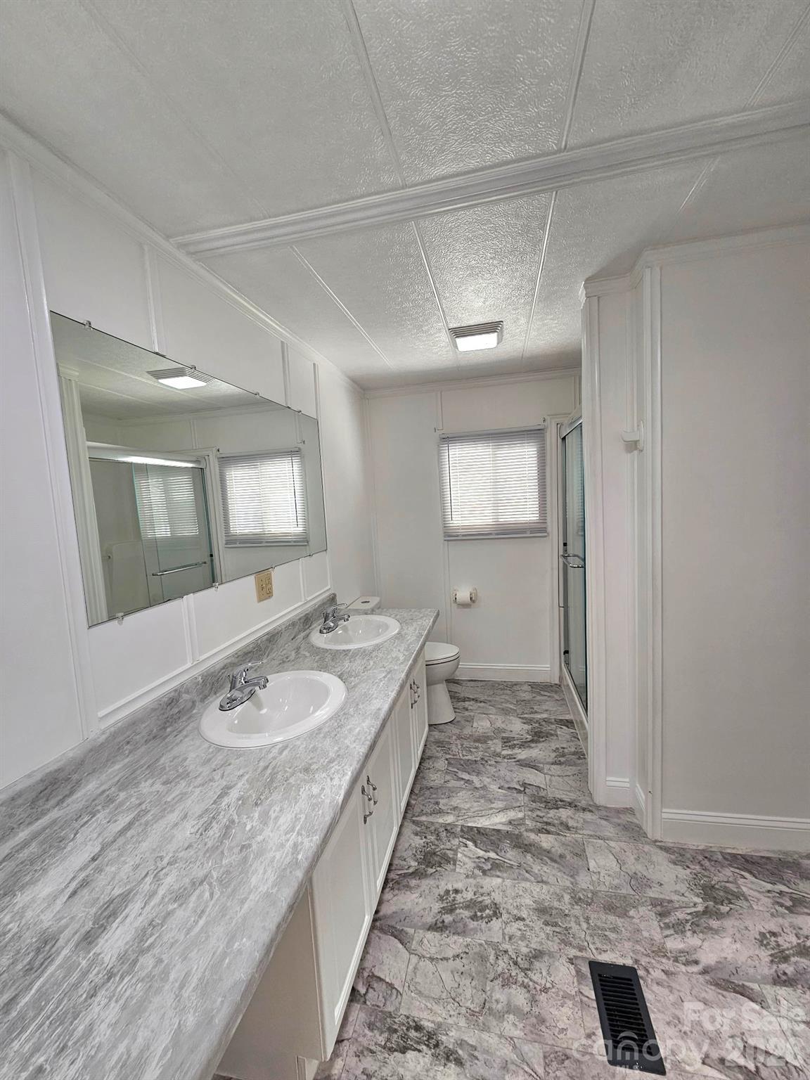 44716 Gold Branch Road Richfield, NC 28137 - Photo 27 of 47 a spacious bathroom with a granite countertop sink a toilet and mirror