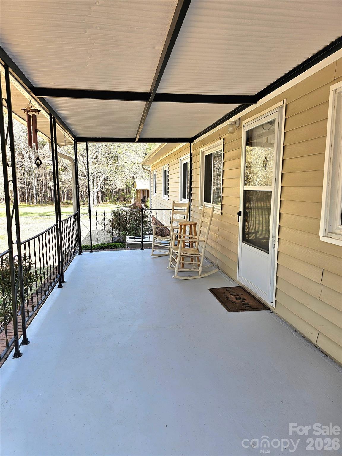 44716 Gold Branch Road Richfield, NC 28137 - Photo 7 of 47 a view of a porch with chairs and floor to ceiling window