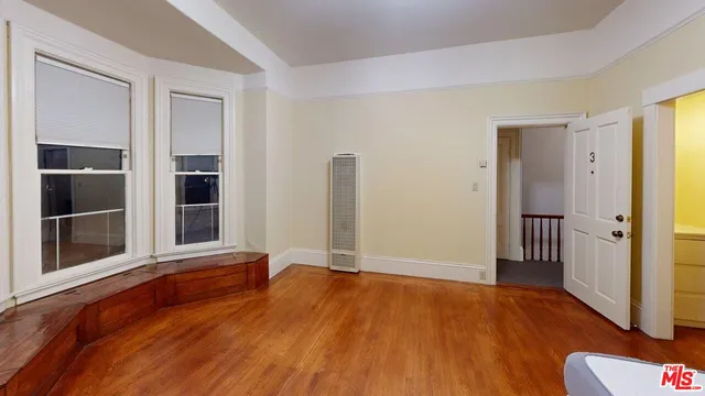 an empty room with wooden floor and closet