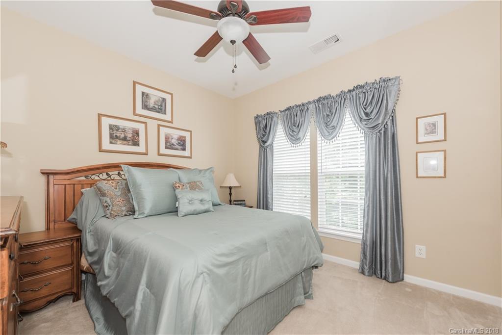 1942 Faison Avenue, Unit 161 Fort Mill, SC 29708 - Photo 15 of 21 a spacious bedroom with a bed and a chandelier