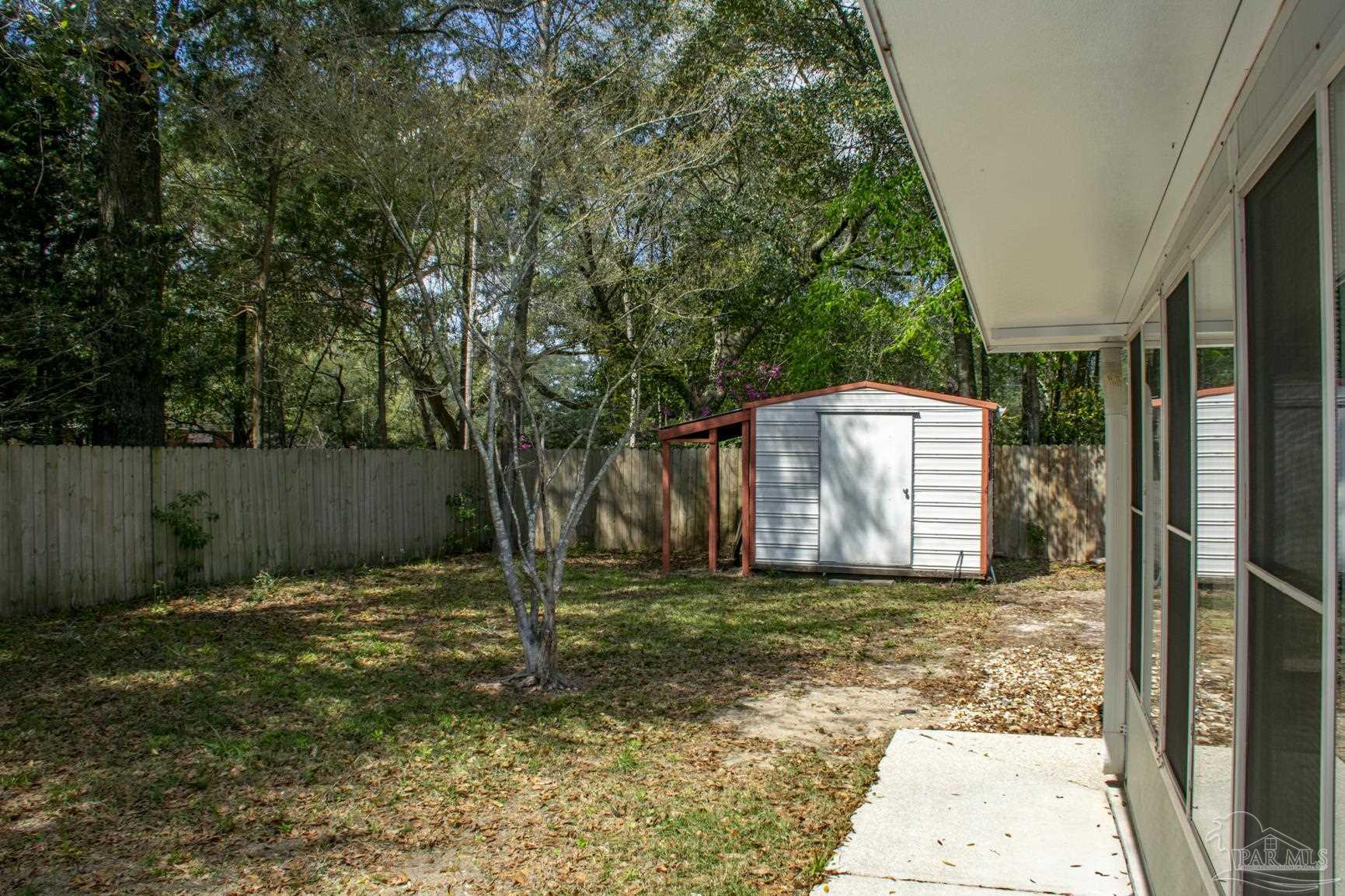 6514 Oakcrest Road Milton, FL 32570 - Photo 20 of 68 a backyard of a house with lots of green space