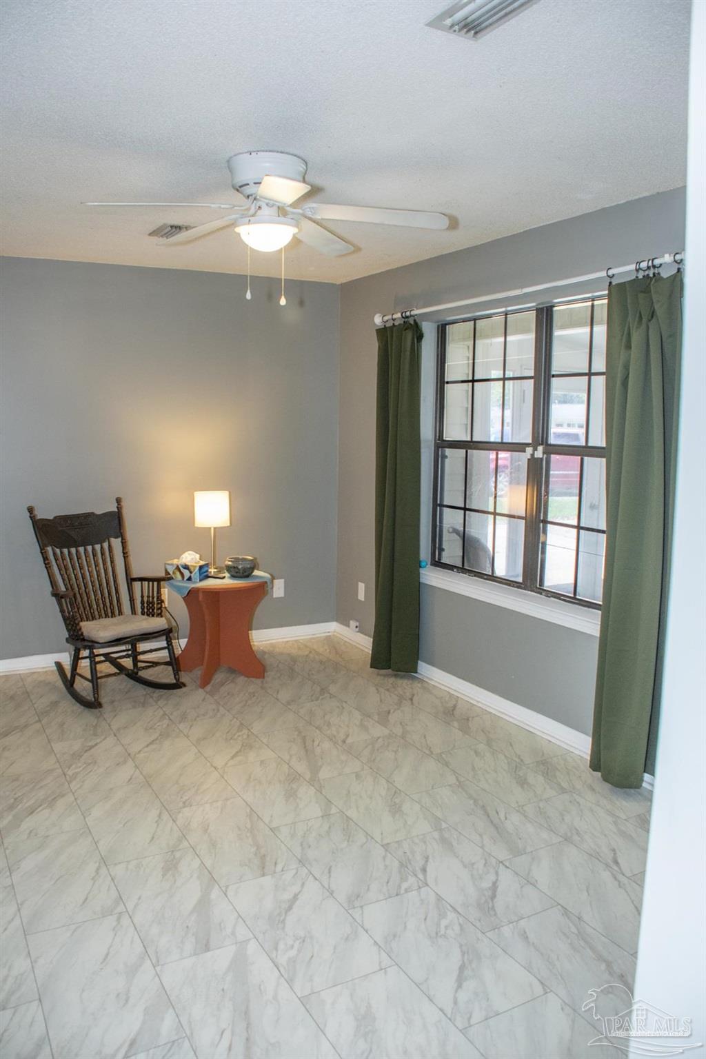 6514 Oakcrest Road Milton, FL 32570 - Photo 23 of 68 a view of a livingroom with a lounge chair and a large window