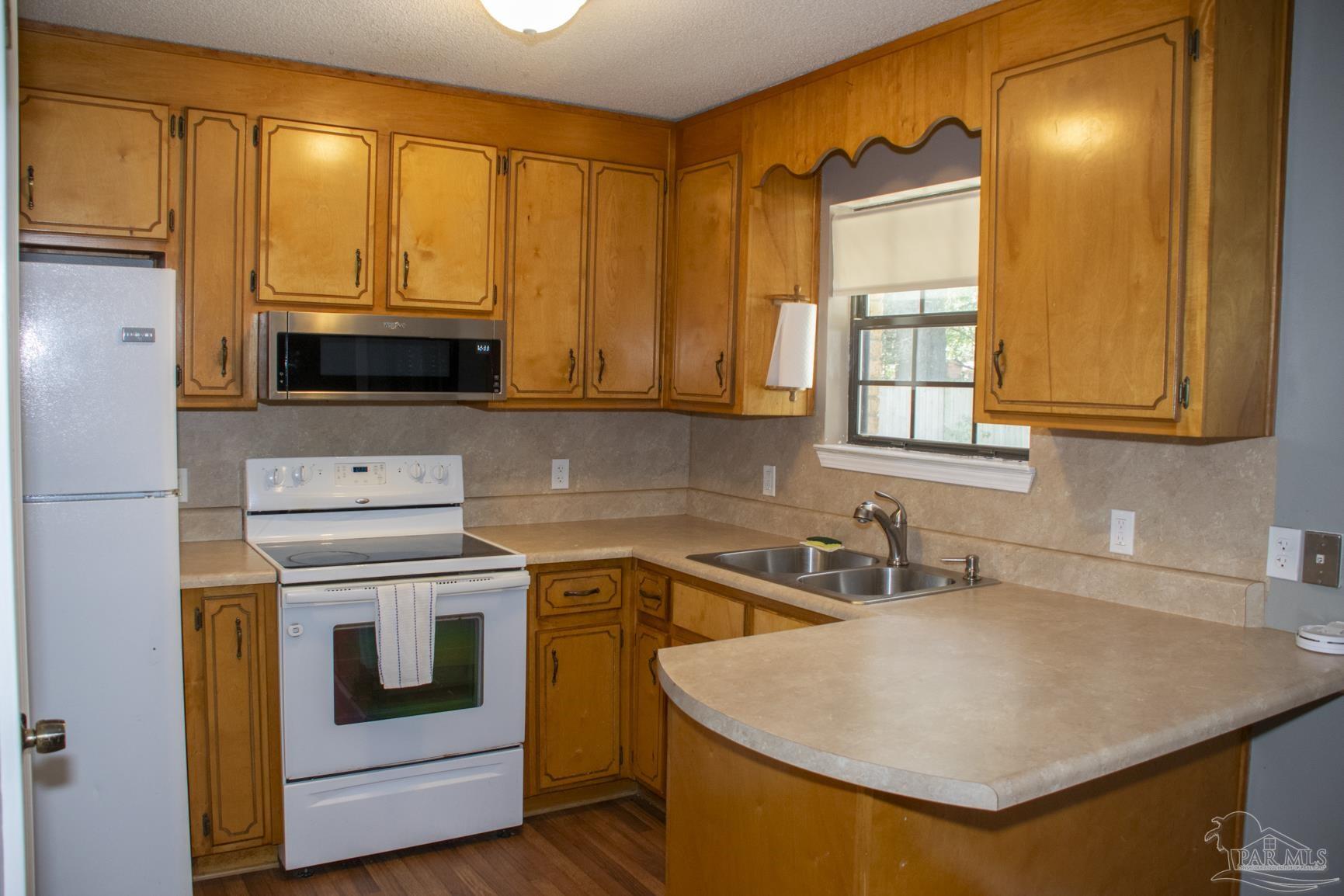 6514 Oakcrest Road Milton, FL 32570 - Photo 29 of 68 a kitchen with a sink a stove and cabinets