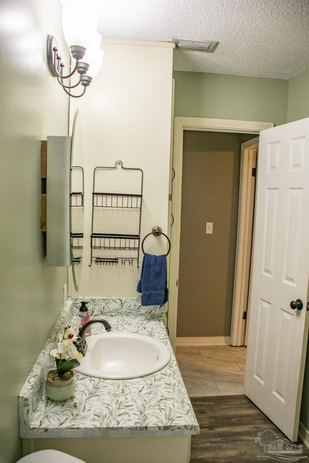 6514 Oakcrest Road Milton, FL 32570 - Photo 42 of 68 a bathroom with a sink a mirror and a shower