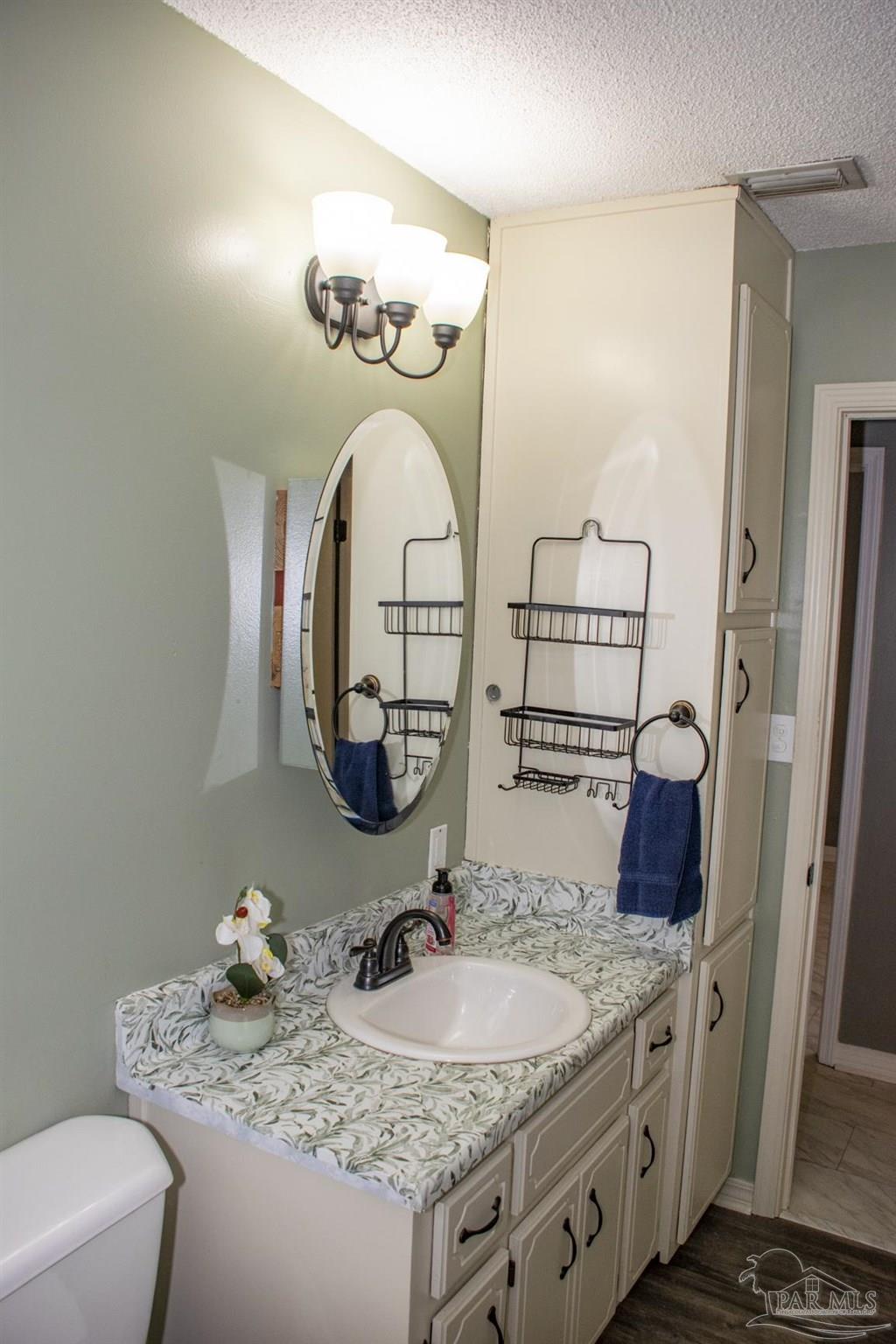 6514 Oakcrest Road Milton, FL 32570 - Photo 44 of 68 a bathroom with a granite countertop sink and a mirror